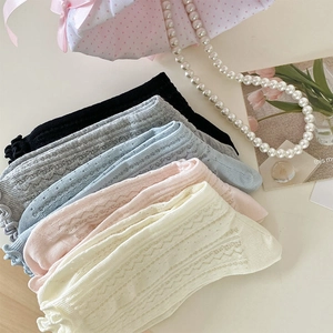 Close-up of five pairs of pastel mesh knit socks with wavy edges and floral patterns