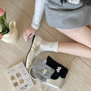 Detailansicht der gerippten Baumwollsocken mit Schleifenstickerei und gewelltem Saum