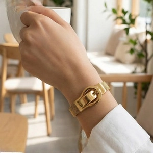 Detail of a vintage-style 18K gold plated mesh belt bracelet with buckle closure