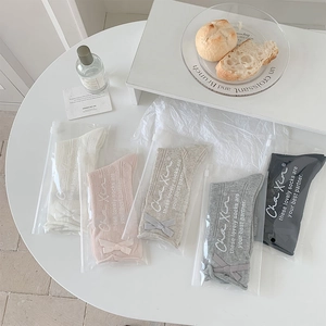 Detail showing five pairs of bow-knot socks in pastel colors with premium packaging