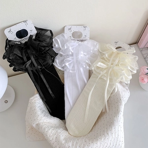 Detailed close-up of Lolita lace socks with double-layer organza and satin bows in a basket