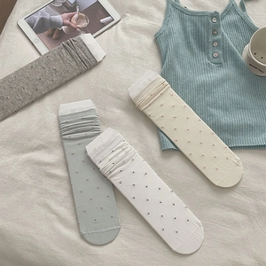 Flat lay of four pairs of ballet style polka dot socks in gray, blue, white, and beige