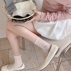 Detail of pink hollow-out breathable mesh socks paired with stylish Mary Jane shoes