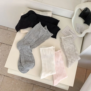 Detail of breathable hollow-out crew socks with rolled cuffs in various pastel colors