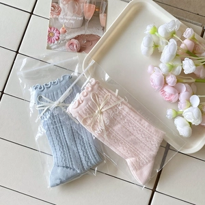 Vue détaillée de chaussettes roses et bleues avec perles, nœuds et bords à volants