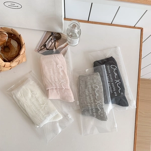 Close-up of four colors of JK style cotton socks in individual zipper packaging bags