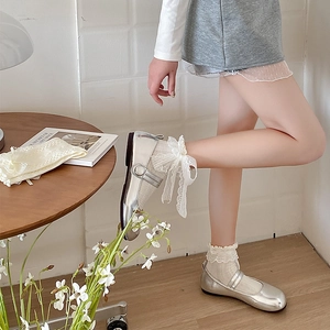 Détail de chaussettes en dentelle Lolita avec nœud et chaussures Mary Jane argentées