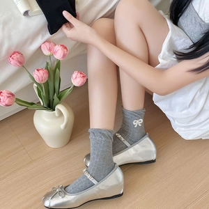 Silberne Mary Jane Ballerinas mit Schleife und graue Socken mit weißen Bändern