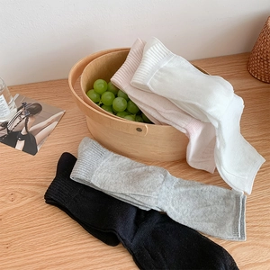 Close-up of assorted ribbed crew socks in neutral tones on a wooden table setup