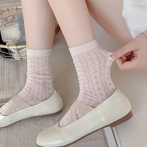 Close-up of beige mesh knit socks showing floral hollow pattern and elastic texture