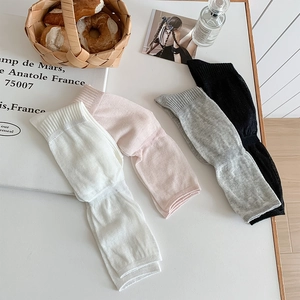 Detailed knit ribbed texture of leg warmers in white, pink, grey and black colors