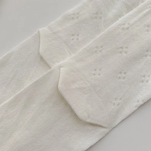 Macro shot of white knit socks featuring breathable hollow patterns and reinforced heel detail