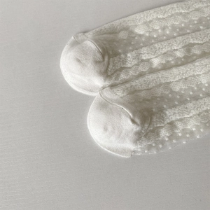 Gros plan de chaussettes en dentelle blanche avec maille ajourée et texture à pois doux