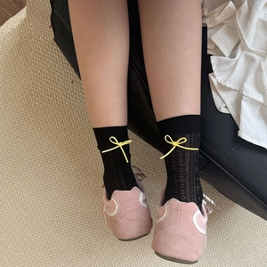 Sweet black mesh crew socks with yellow bow detail paired with pink sneakers