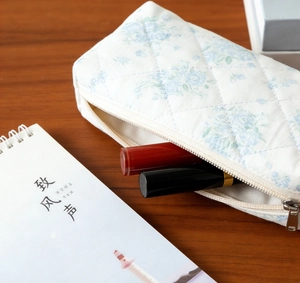 Detail of blue floral quilted makeup bag showing spacious interior for cosmetics