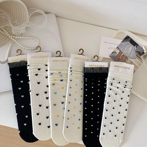 Mise à plat de chaussettes en dentelle avec motifs de cœurs et pois et décor français