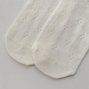 Close-up of white hollow star pattern lace socks with breathable mesh knit details