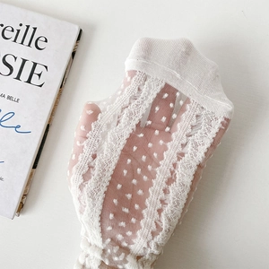 Détail macro de chaussettes en dentelle blanche transparente avec mesh à pois et bords