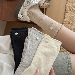 Detail of lace floral pattern and button trim on breathable mesh crew socks for women