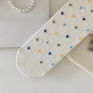 Détail de chaussettes blanches à pois colorés avec bordure en dentelle élégante