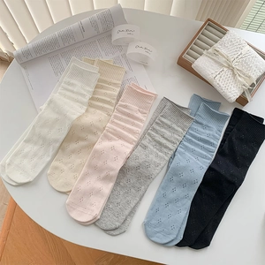 Flat lay of six pairs of breathable hollow-out knit mid-calf socks in various colors