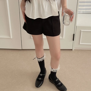 Détail de chaussettes en résille noire avec dentelle blanche et chaussures Mary Jane