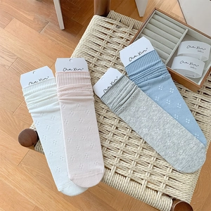 Detail of four-color hollow mesh slouch socks in white, pink, gray, and blue tones
