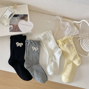 Details von süßen Rüschensocken mit Schleifenknoten und Perlen in vier Farben