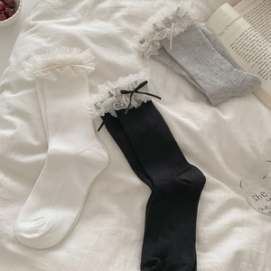 Détail de chaussettes à côtes avec bordure en dentelle et nœud en satin élégant