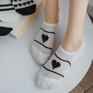 Gros plan sur les chaussettes invisibles en mesh blanc avec broderie cœur pixel
