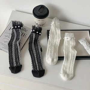 Détail de chaussettes en résille avec perles et bords à volants sur fond de style de vie