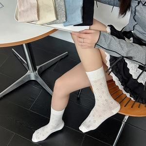 Close-up of diamond pattern hollow mesh socks in cream, grey, blue, and black