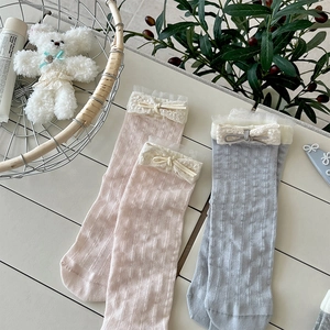 Detail of pink and grey cotton socks with delicate lace trim and ribbon bow accents