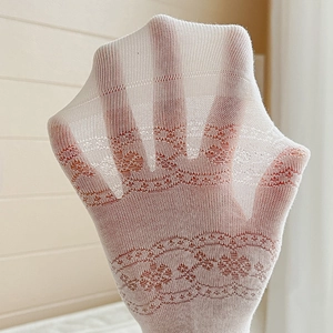 Macro view of white floral lace socks showing breathable mesh and translucent texture