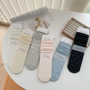 Detail of vintage hollow-out knitted mid-tube socks in multiple pastel colors
