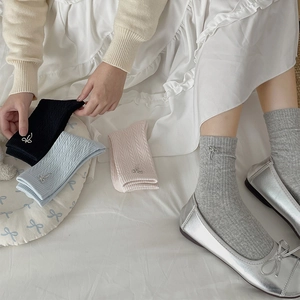 Detail of cable knit crew socks featuring elegant silver metal bow charms in four colors