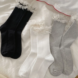 Détail de chaussettes en coton côtelé avec bordure en dentelle et petits nœuds décoratifs