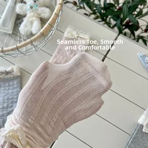 Detail of boneless toe seam on pink mesh baby socks with lace and bow decoration