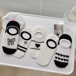 Vue à plat de cinq paires de chaussettes invisibles avec broderie cœur et nœud sur plateau