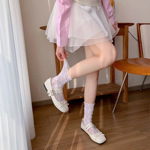 Close-up of white floral lace crew socks paired with chic matte Mary Jane shoes