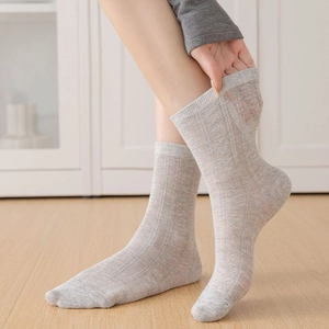 Detail of light gray ballet style mesh socks with vertical stripes and hollow knit texture