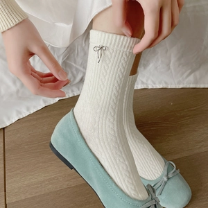 White cotton mid-tube socks with cable knit texture and silver metal bow decoration