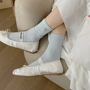Light blue cable knit crew socks with silver bow accents and white satin Mary Jane shoes