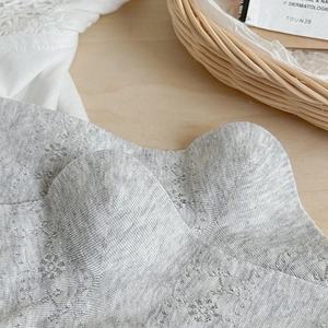 Close-up of grey lace mesh socks with delicate hollow floral knit patterns and textures
