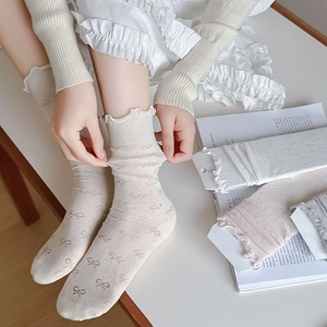 Détails de chaussettes style ballerine avec motifs jacquard à nœuds et bords volantés