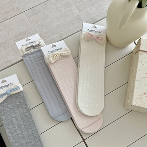 Detail of lace-edged ribbed socks with colorful bows in four Morandi colors