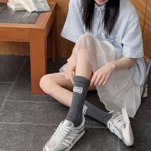 Detail of dark gray ribbed cotton socks with delicate white lace embroidery on the side