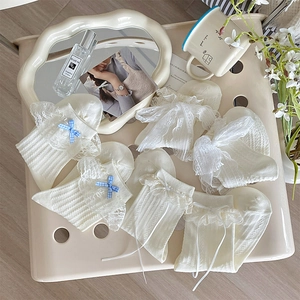 Détail de chaussettes Lolita blanc lait avec bordure en dentelle et nœuds à carreaux