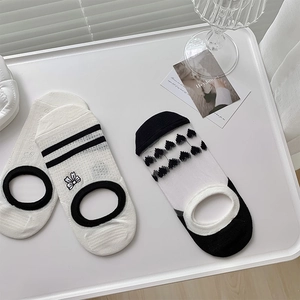 Détail de broderie nœud et maille jacquard cœur sur chaussettes invisibles respirantes