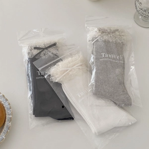Trois paires de chaussettes douces en résille avec dentelle et rubans en noir, blanc et gris
